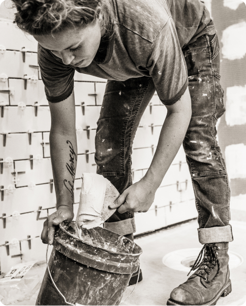 femme ouvriere du batiment prepare un enduit dans un sceau